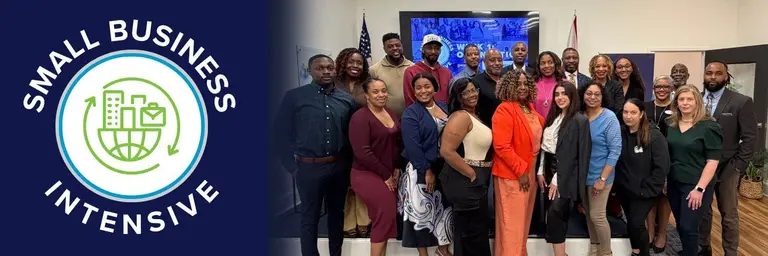 A large, diverse group of smiling professionals posing together in a brightly lit room, positioned next to a blue graphic with the "Small Business Intensive" logo.