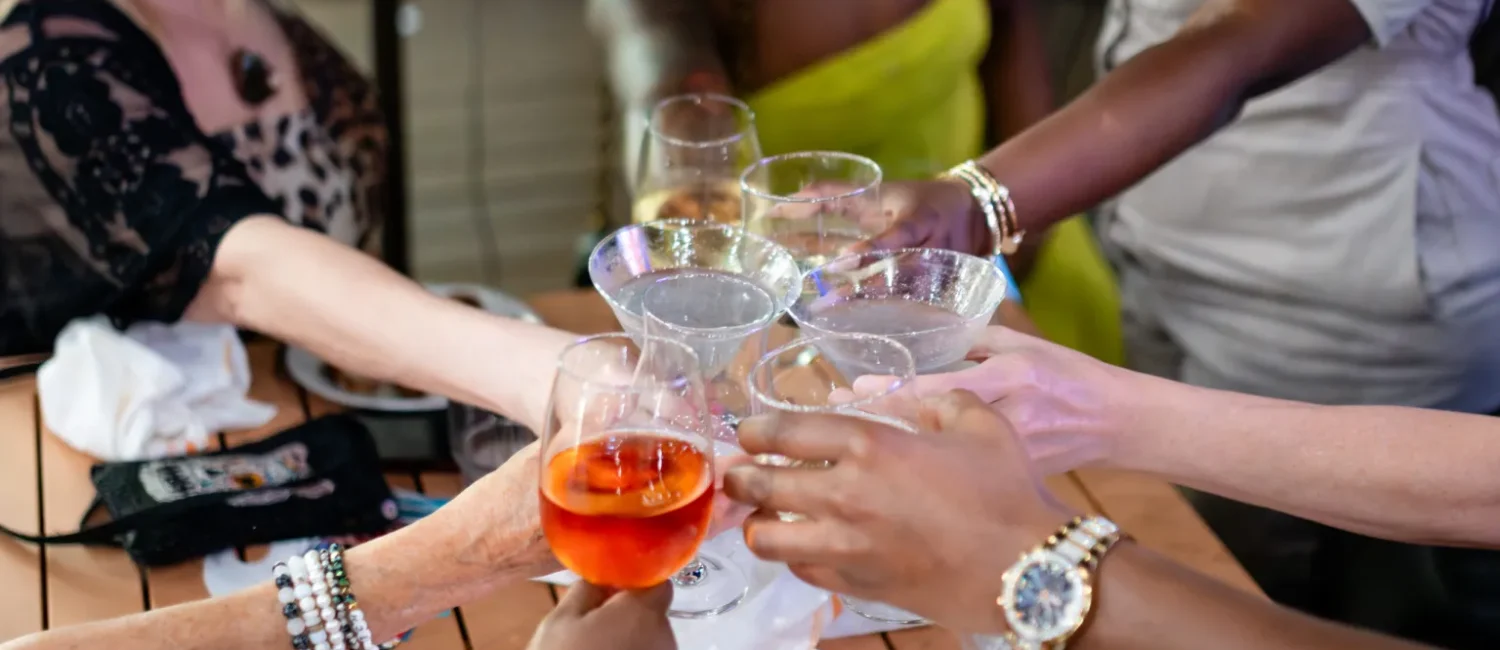 Several people reaching glassware together in a "Cheers" motion