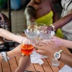 Several people reaching glassware together in a "Cheers" motion