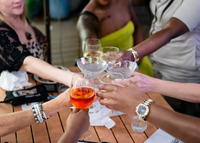 Several people reaching glassware together in a "Cheers" motion