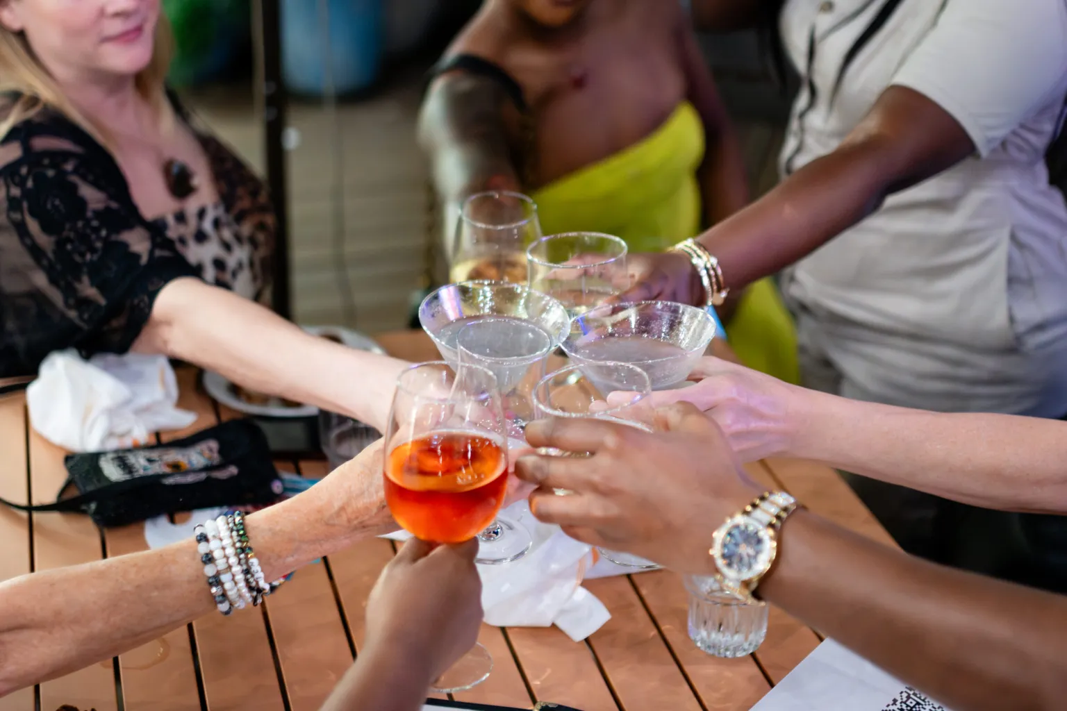 Several people reaching glassware together in a "Cheers" motion
