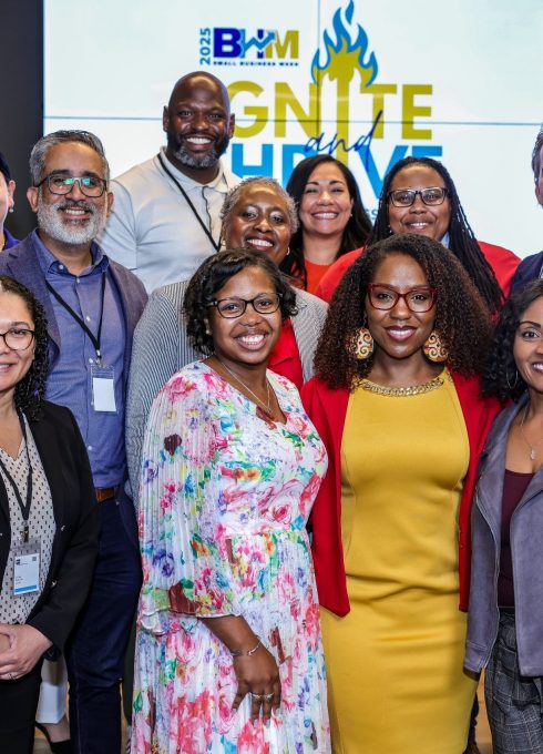 Photo of IEO team members and event attendees smiling on stage